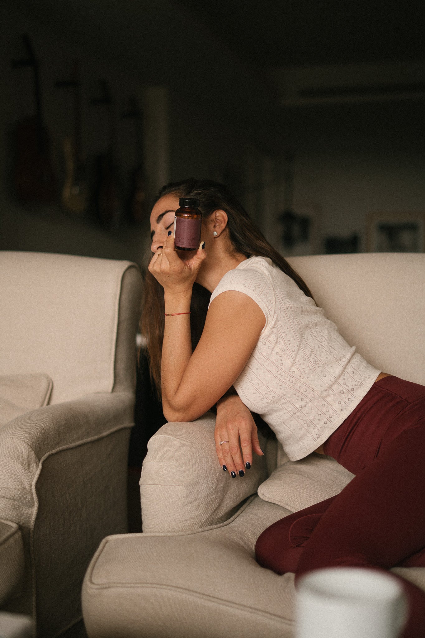 mujer con dolor menstrual sosteniendo el suplemento Ciclo 360 de SANA Nutrients