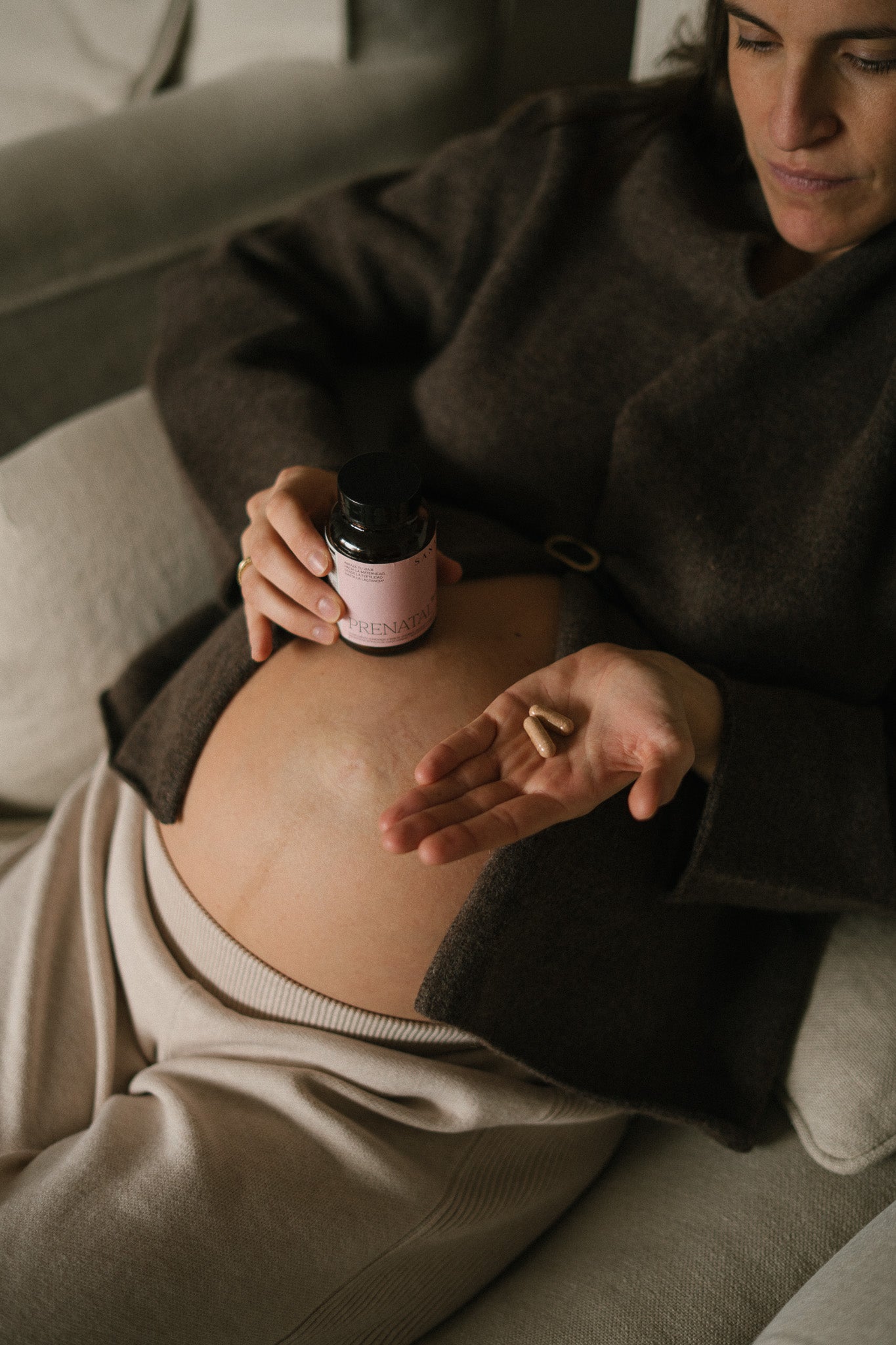 Mujer embarazada tomando cápsulas de suplemento prenatal Prenatal 360 de SANA Nutrients durante el embarazo