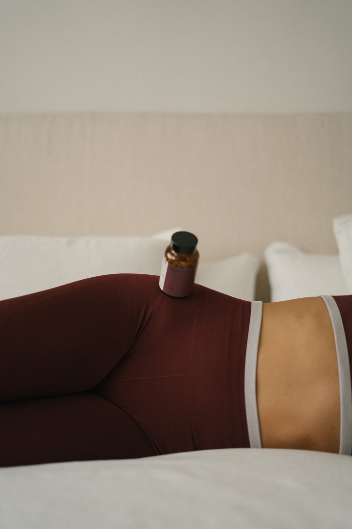 Ciclo 360 de SANA sobre el abdomen de una mujer, suplemento natural para el ciclo menstrual y bienestar femenino